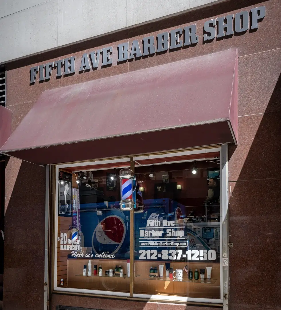 Fifth Ave Barber Shop front located at the corner of West 35th St and 5th Avenue in Midtown NYC